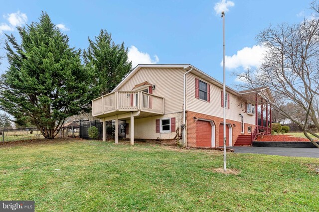 exterior space with a lawn, a garage, and a wooden deck