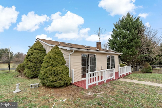 view of home's exterior with a lawn and a deck