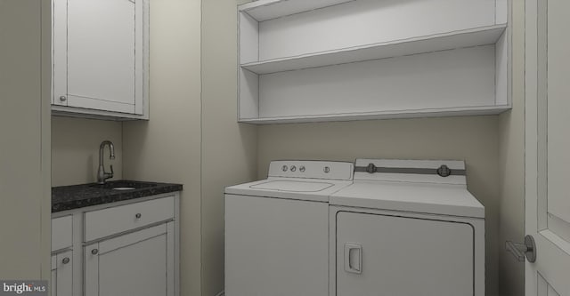 washroom with cabinets, independent washer and dryer, and sink