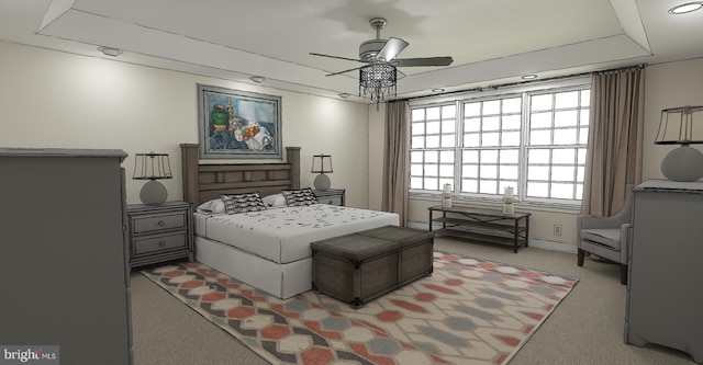 bedroom with a raised ceiling, ceiling fan, and light colored carpet