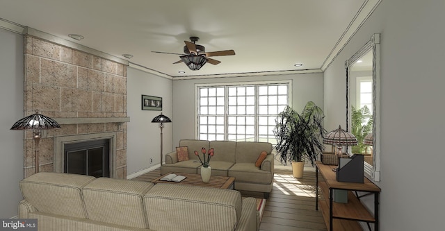 living room featuring hardwood / wood-style floors, ceiling fan, crown molding, and a tiled fireplace