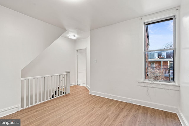 bonus room with light hardwood / wood-style flooring and a healthy amount of sunlight