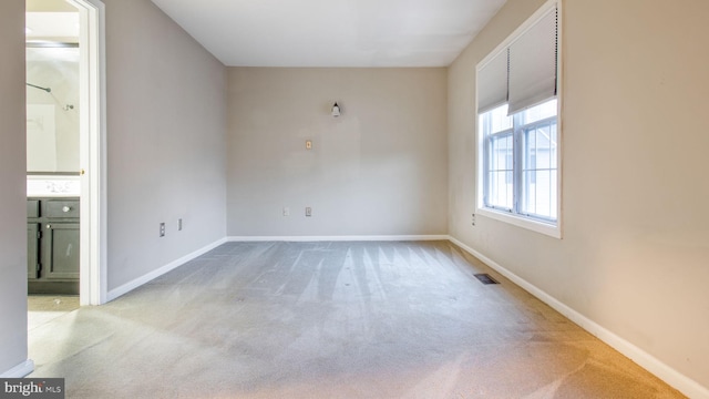 unfurnished room featuring light carpet