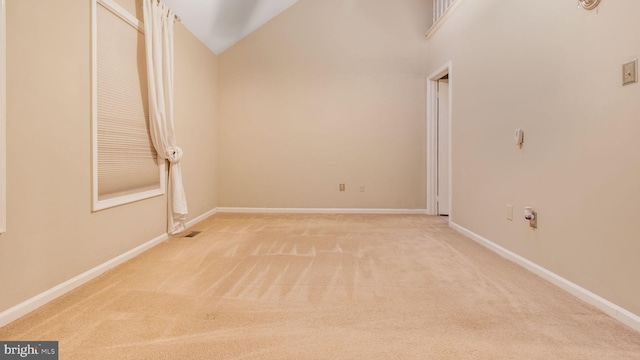 spare room with carpet floors and vaulted ceiling