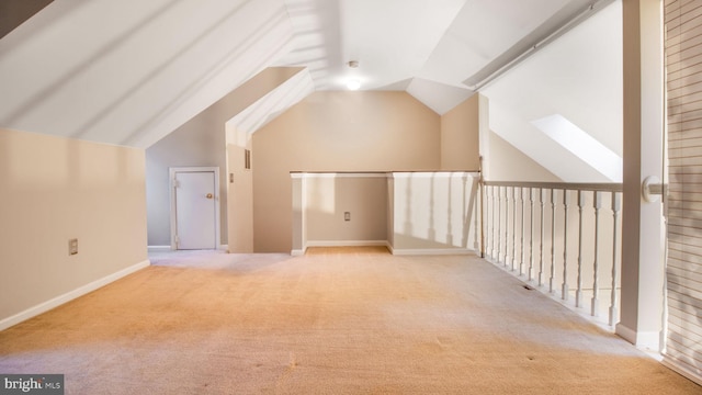 additional living space with light colored carpet and vaulted ceiling