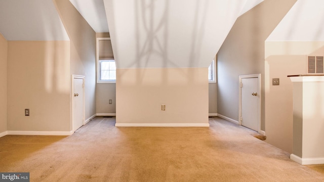 bonus room with a wealth of natural light, light carpet, and vaulted ceiling