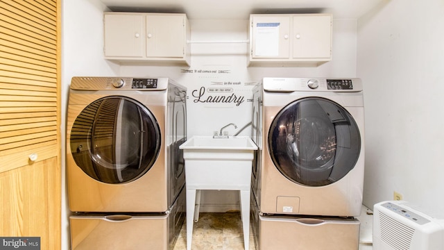 laundry room featuring cabinets, washer and clothes dryer, and sink