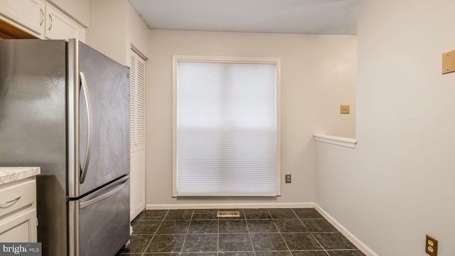 kitchen with white cabinets and stainless steel refrigerator