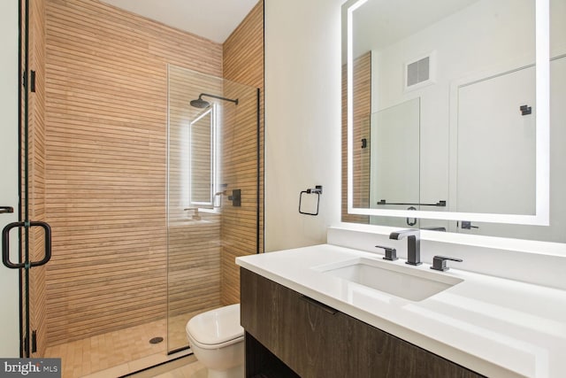 bathroom featuring an enclosed shower, vanity, and toilet