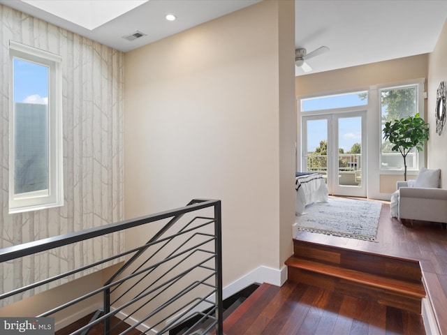 stairs with hardwood / wood-style floors, french doors, and ceiling fan