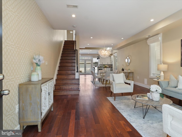 living room with dark hardwood / wood-style floors and a notable chandelier