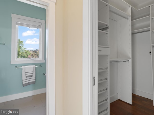 spacious closet with dark hardwood / wood-style flooring