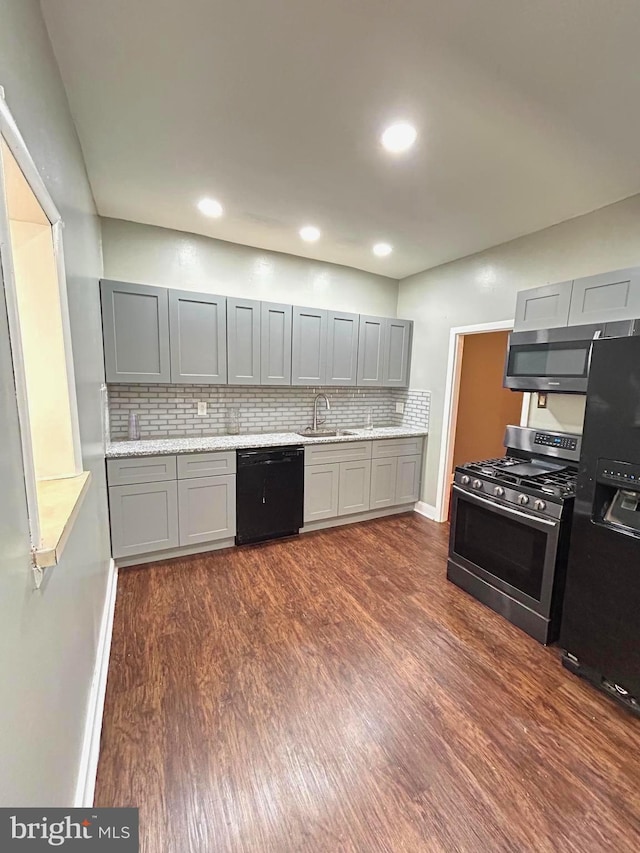 kitchen with sink, dark hardwood / wood-style flooring, backsplash, gray cabinets, and black appliances