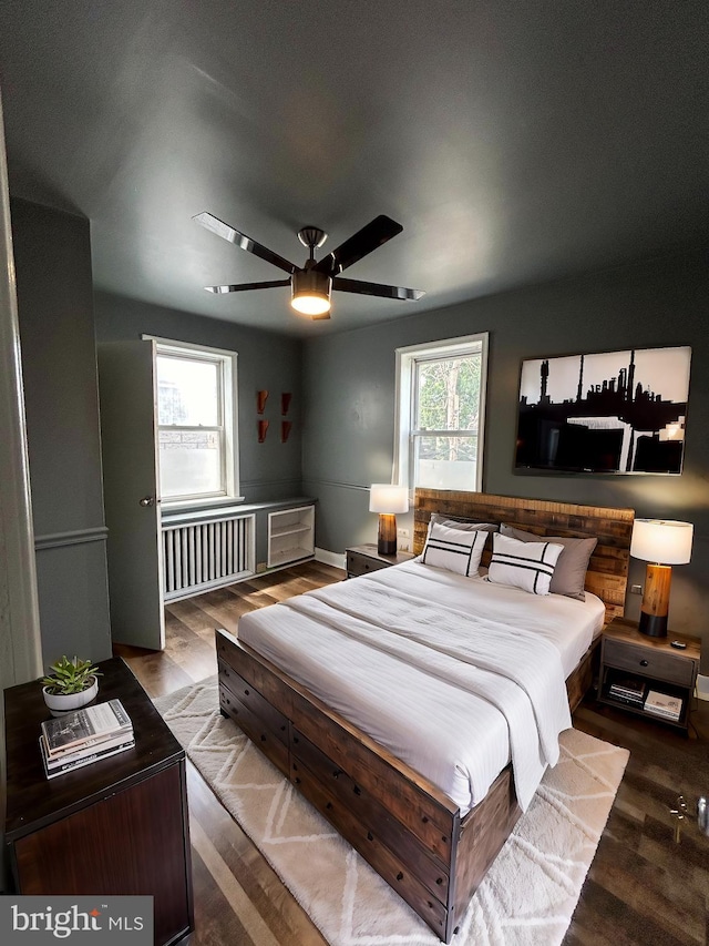 bedroom with ceiling fan, radiator heating unit, and hardwood / wood-style floors