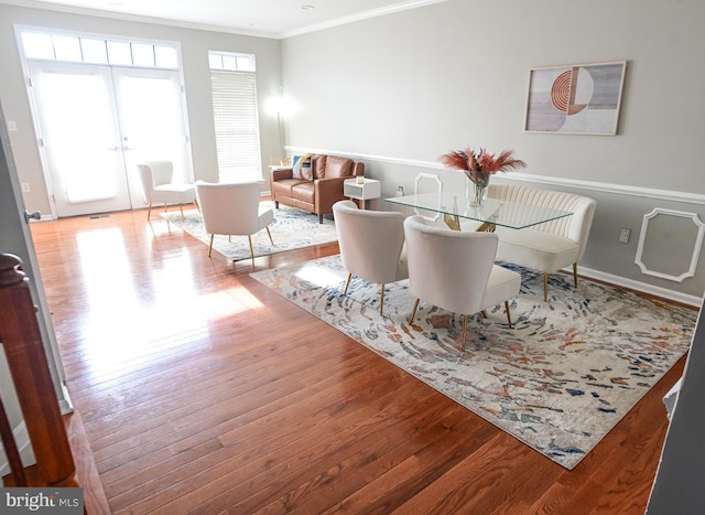 dining room featuring french doors, ornamental molding, and hardwood / wood-style flooring