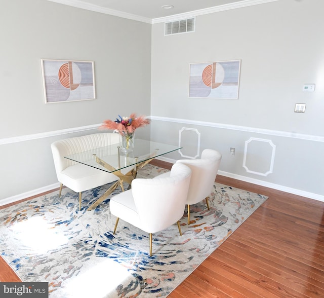 dining room featuring hardwood / wood-style floors and ornamental molding