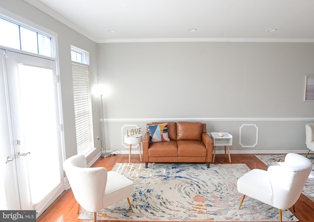 sitting room with crown molding, plenty of natural light, and light hardwood / wood-style floors