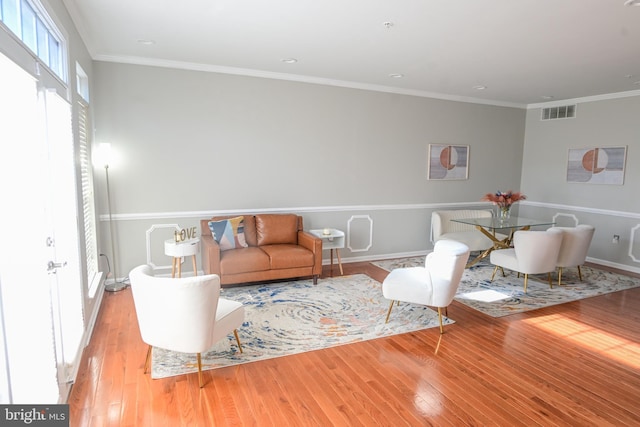 living room featuring light wood-type flooring and crown molding