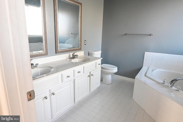 bathroom with tile patterned flooring, vanity, toilet, and tiled bath