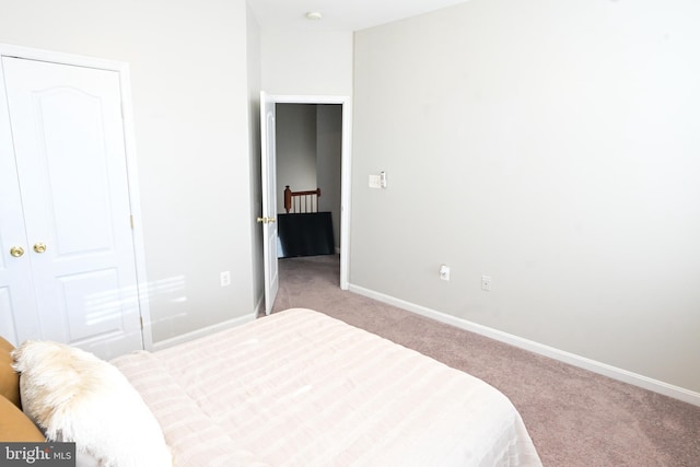 bedroom with light carpet and a closet