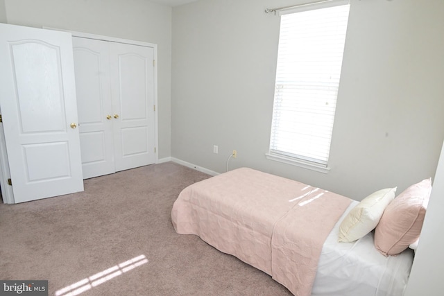 bedroom featuring a closet and light colored carpet