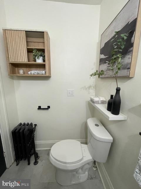 bathroom featuring baseboards, toilet, and marble finish floor