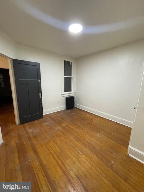 unfurnished bedroom with hardwood / wood-style floors and baseboards