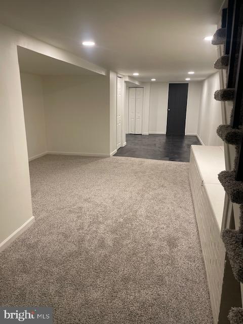 finished basement featuring recessed lighting, dark carpet, and baseboards