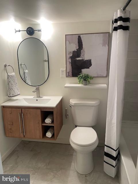 bathroom featuring marble finish floor, toilet, vanity, and a shower with curtain