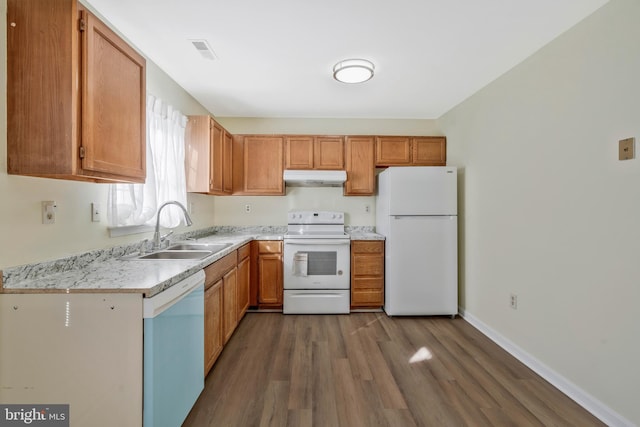 kitchen featuring sink, wood-type flooring, and white appliances