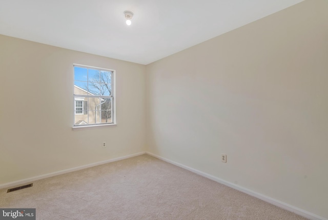 spare room featuring light colored carpet