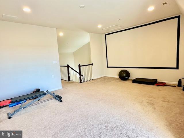 carpeted home theater featuring lofted ceiling