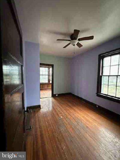 empty room featuring dark hardwood / wood-style floors and ceiling fan