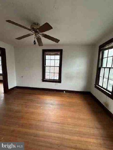 spare room with hardwood / wood-style flooring and ceiling fan