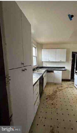 kitchen featuring white cabinets, black dishwasher, and sink