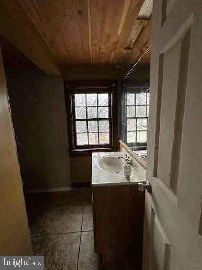 bathroom with tile patterned flooring, vanity, and wood ceiling