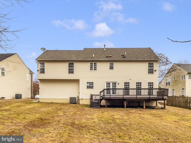 rear view of house featuring a deck, central AC unit, and a lawn