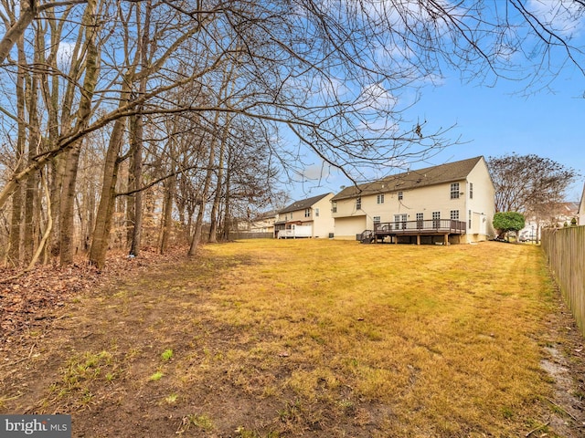 rear view of house with a lawn and a wooden deck