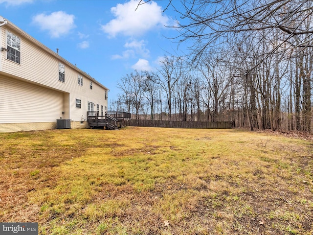 view of yard with central air condition unit and a wooden deck