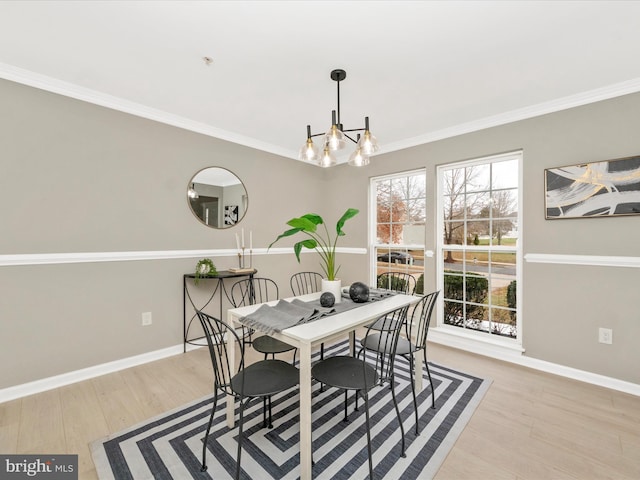 dining space featuring light hardwood / wood-style flooring, crown molding, and a notable chandelier