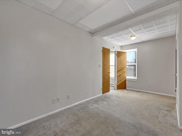 spare room featuring carpet floors and a drop ceiling