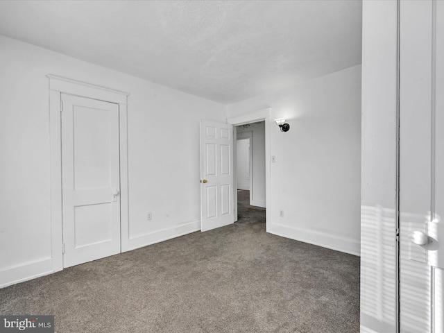 unfurnished bedroom with dark carpet