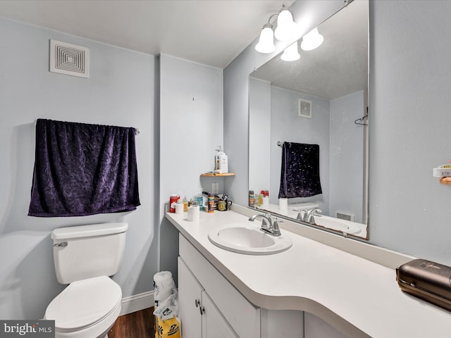 bathroom with hardwood / wood-style flooring, vanity, and toilet