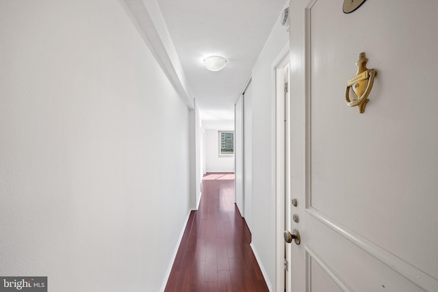 hall with dark wood finished floors, visible vents, and baseboards