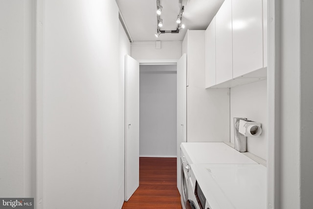 clothes washing area with dark wood-type flooring and track lighting