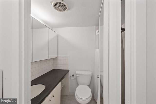 bathroom featuring toilet, tasteful backsplash, visible vents, and vanity