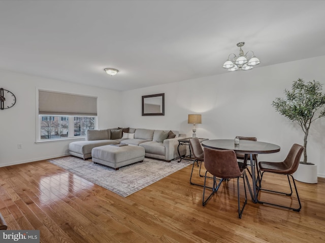 living room with light hardwood / wood-style floors and a notable chandelier