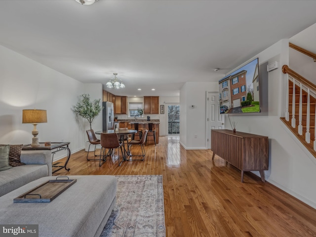 living room featuring an inviting chandelier and light wood-type flooring