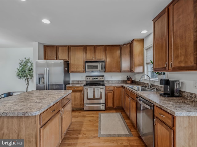 kitchen with a center island, light wood-type flooring, stainless steel appliances, and sink