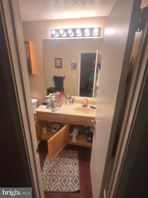 bathroom with a textured ceiling and vanity